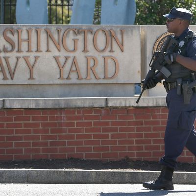WASHINGTON, DC - SEPTEMBER 17: A police officer stands guard at the front gate of the Washington Naval Yard September 17, 2013 in Washington, DC. Yesterday a defense contractor named Aaron Alexis allegedly killed at least 13 people during a shooting rampage at the Navy Yard before being killed by police. (Photo by Mark Wilson/Getty Images)
