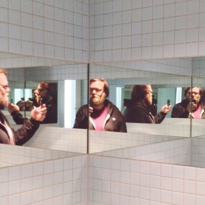 Multiple Reflection Of Man Taking Self Portrait Through Phone In Restroom