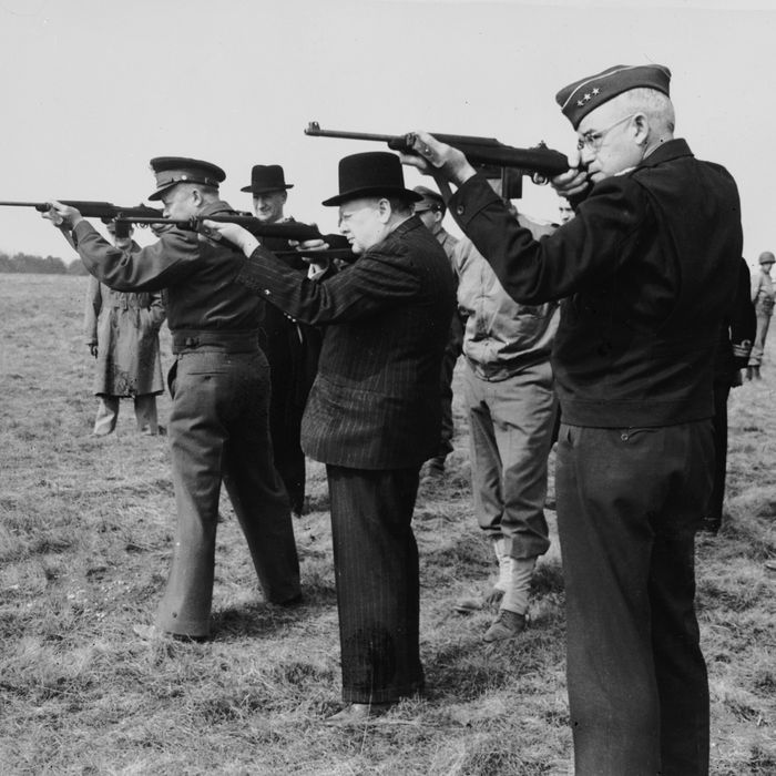 1944: From left to right: American General Dwight D Eisenhower (1890 - 1969, later the 34th President of the United States), British Prime Minister Winston Churchill (1874 - 1965) and Lt-Gen Omar Bradley (1893-1981), shooting with the American Army's new carbine at an American armoured troops camp in England. The Allied war chiefs are escorting the British prime minister on a tour of inspection. (Photo by Keystone/Getty Images)