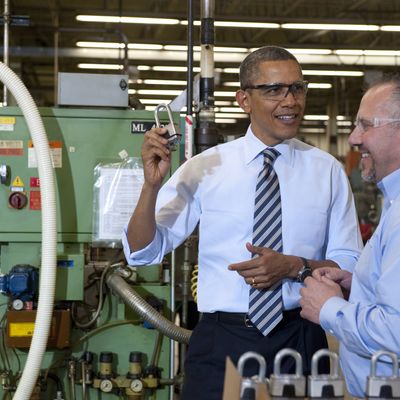 US President Barack Obama holds up a lock as he tours the manufacturing facility at Master Lock, maker of security locks, alongside Bob Rice (R), Master Lock Senior Vice President, prior to speaking on the economy in Milwaukee, Wisconsin, on February 15, 2012.