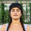 Mid adult woman breathing deeply with eyes closed outdoors