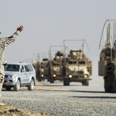 CAMP VIRGINIA, KUWAIT - DECEMBER 18: Soldiers wave to colleagues as a section of the last American military convoy to depart Iraq from the 3rd Brigade, 1st Cavalry Division arrives after crossing over the border into Kuwait on December 18, 2011 in Camp Virginia, Kuwait. Around 500 troops from the 3rd Brigade, 1st Cavalry Division ended their presence on Camp Adder, the last remaining American base, and departed in the final American military convoy out of Iraq, arriving into Kuwait in the early morning hours of December 18, 2011. All U.S. troops were scheduled to have departed Iraq by December 31st, 2011. At least 4,485 U.S. military personnel died in service in Iraq. According to the Iraq Body Count, more than 100,000 Iraqi civilians have died from war-related violence. (Photo by Mario Tama/Getty Images)
