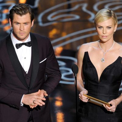 Actors Chris Hemsworth (L) and Charlize Theron speak onstage during the Oscars at the Dolby Theatre on March 2, 2014 in Hollywood, California. 