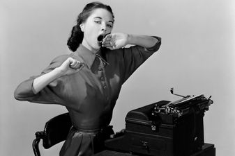 Woman yawning at a typwriter, 1950.