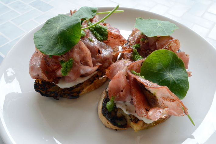 Griddled mortadella with whipped ricotta and a purée of sunflower seeds, lemon, and nasturtium leaves.