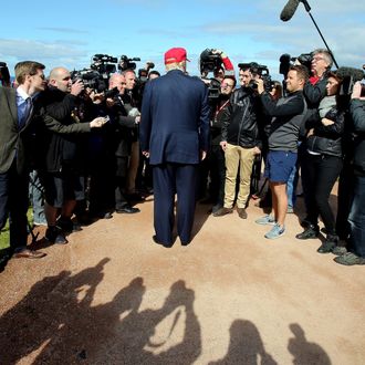 US billionaire Donald Trump (Back Facing) speaks to the media as he arrives at the Women's British Open Golf Championships in Turnberry, Scotland, on July 30, 2015. 