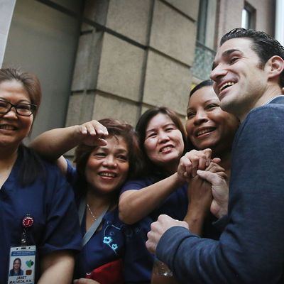 NEW YORK, NY - NOVEMBER 11: Dr. Craig Spencer, who was diagnosed with Ebola in New York City last month, greets some of the nurses who helped him to recovery at a news conference at New York's Bellevue Hospital after being declared free of the disease on November 11, 2014 in New York City. Spencer, a 33 year old Doctors Without Borders physician, was diagnosed last month after returning from treating patients in Guinea. He became the first person to test positive for the deadly virus in the New York City and was treated in isolation at the hospital. Spencer's case started a controversy about voluntary quarantine after he travelled the city in the days after returning from Africa unaware that he was carrying the virus. After being released, Spencer he is expected to return to his apartment in the New York City neighborhood of Hamilton Heights. (Photo by Spencer Platt/Getty Images)