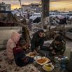 Palestinian family breaks their fast in the rubble of a house destroyed in an Israeli attack