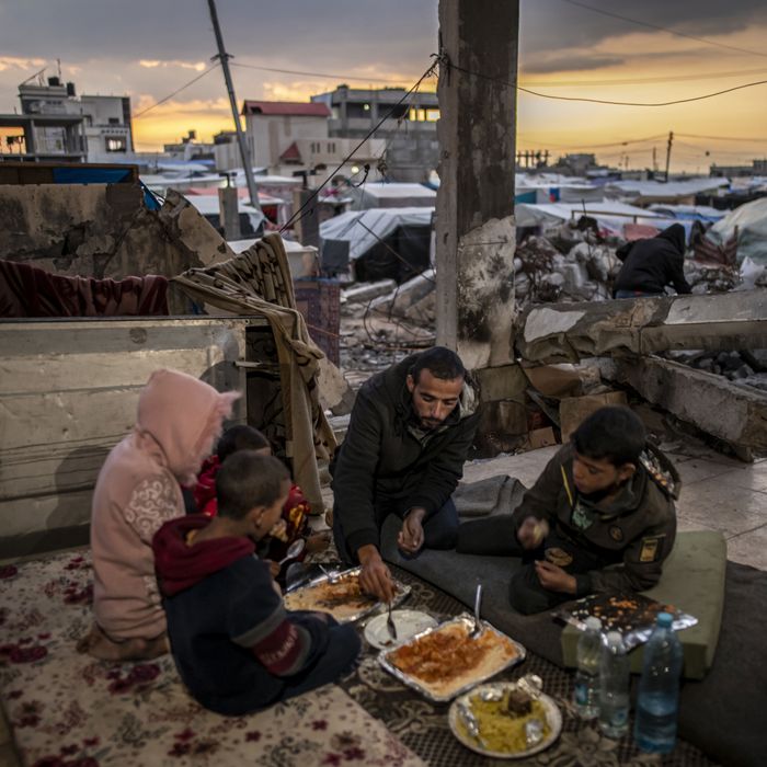 Palestinian family breaks their fast in the rubble of a house destroyed in an Israeli attack