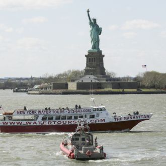 A tourist boat sails past the Statue of Liberty