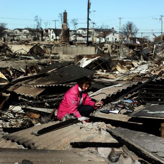 Kathy Lahey sifts through her damaged home for items to save November 4, 2012 in the Breezy Point neighborhood of the Queens borough of New York City. With the death toll currently over 100 and millions of homes and businesses without power, the US east coast is attempting to recover from the effects of floods, fires and power outages brought on by Superstorm Sandy.