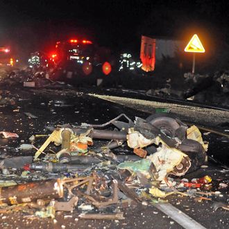 The wreckage of a U.S.AH-64 Apache helicopter is strewn along a road in Wonju, South Korea, Monday, Nov. 23, 2015. The helicopter crashed in South Korea on Monday, killing two people on board, police said.