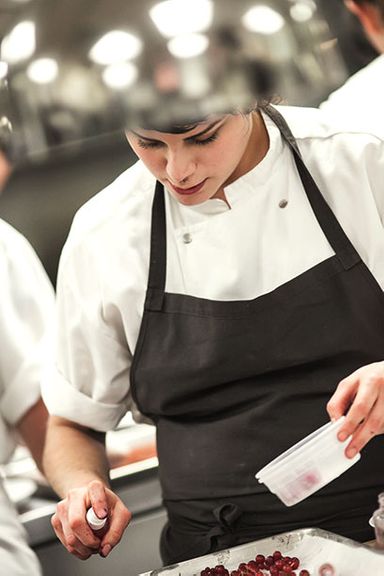 Rosio Sanchez sprays currants with rose oil before plating.