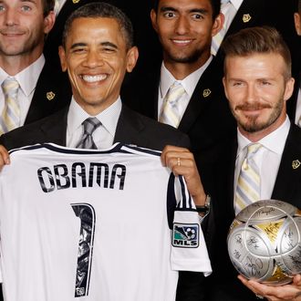 WASHINGTON, DC - MAY 15: U.S. President Barack Obama (L) poses for photographs with the Major League Soccer champions Los Angeles Galaxy and their mid-fielder David Beckham in the East Room of the White House May 15, 2012 in Washington, DC. Players from the Galaxy also participated in a 