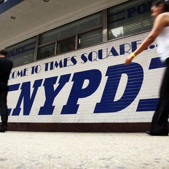 People walk by a New York Police Department (NYPD) outpost in Times Square