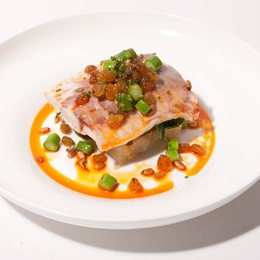 Salt crusted striped bass, potato confit, spinach, golden raisins, asparagus, toasted pine nuts & smoked paprika
