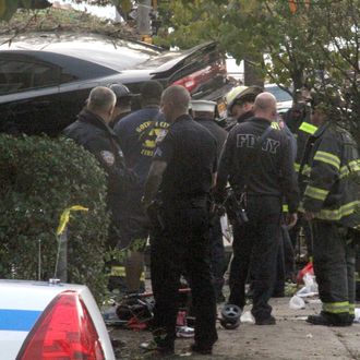 First responders examine an automobile after its driver lost control and plowed into a group of trick-or-treaters Saturday, Oct. 31, 2015 in New York. Three people were killed in the, including a 10-year-old girl. Several others were injured. (AP Photo/David Greene)