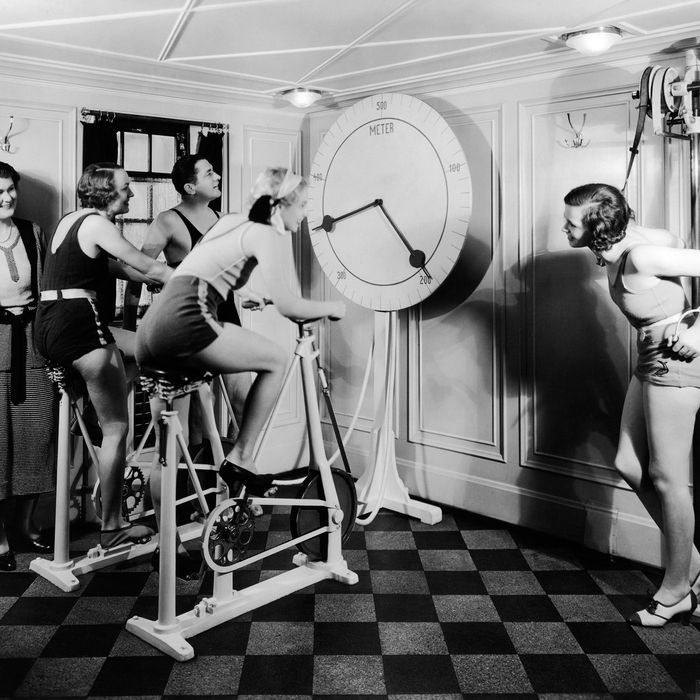 1920s group 4 women one man in exercise gym looking at clock