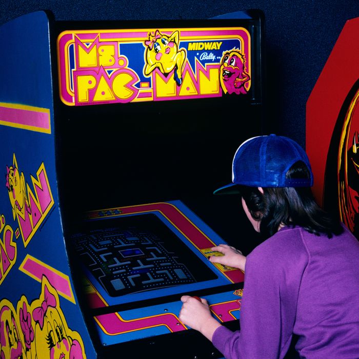 Teen Girl Wear Baseball Cap Playing Ms. Pac Man Video Game In Arcade 