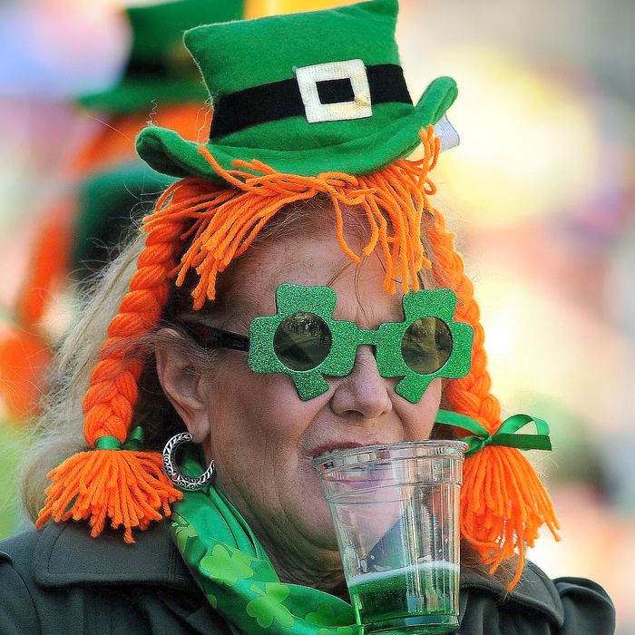 Mary Steffens, of Duluth, Ga., holds a cup of green beer in her teeth while she tries to take a picture during Savannah’s St. Patrick’s Day parade, Saturday, March, 16, 2013, in Savannah, Ga. Thousands of gaudy green revelers Saturday crammed the oak-shaded squares and sidewalks of downtown Savannah for the St. Patrick's Day celebration that's a 189-year-old tradition in Georgia's oldest city. (AP Photo/Stephen Morton)