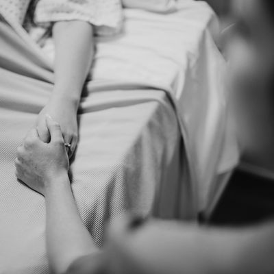 Nurse holding her patients hand