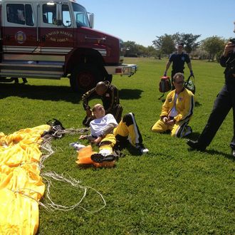 New York Yankees GM Brian Cashman lies on the ground after breaking his ankle on a second tandem parachute jump with Sergeant First Class Noah Watts (center) of the Army Golden Knights parachute team at Homestead Air force Base in Homestead, Florida. (Photo by John Harper/NY Daily News via Getty Images)