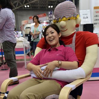 An employee of Japan's nursing care goods maker Unicare demonstrates an easy chair for cognitively impaired persons 