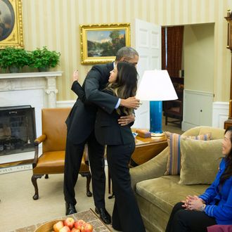 24 Oct 2014, Washington, DC, USA --- President Barack Obama hugs Ebola survivor Nina Pham in the Oval Office of the White House in Washington, Friday, Oct. 24, 2014. Pham, the first nurse diagnosed with Ebola after treating an infected man at a Dallas hospital is free of the virus. The 26-year-old Pham arrived last week at the NIH Clinical Center. She had been flown there from Texas Health Presbyterian Hospital Dallas. Pham's mother Diana, center, and sister Cathy Pham watch. (AP Photo/Evan Vucci) --- Image by ? Evan Vucci/AP/Corbis
