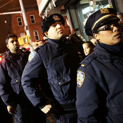  Police officers line-up to pay their respects at a memorial during a vigil for two New York City police officers at the location where they were killed, December 21, 2014 in New York City. The police officers were shot execution style Saturday afternoon as they sat in their marked police car on a Brooklyn street corner. The suspect, who allegedly shot his girlfriend in Baltimore earlier in the day, is believed to have been motivated by the deaths of Eric Garner and Michael Brown. (Photo by Spencer Platt/Getty Images)