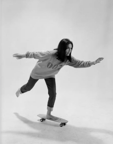 Studio Photos of Gloria Steinem Riding a Skateboard With a 007 James Bond Sweatshirt, 1965