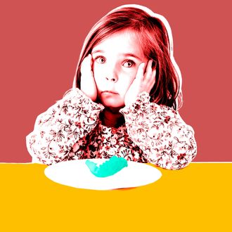 Girl (3-4) sitting at table with plate, close-up