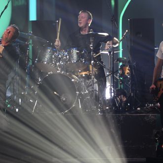 Damon Albarn (L) sings with drummer Dave Rowntree (C) and bassist Alex James (r) as the British alternative rock band Blur perform live on stage at the end of the BRIT Awards 2012 in London on February 21, 2012. 