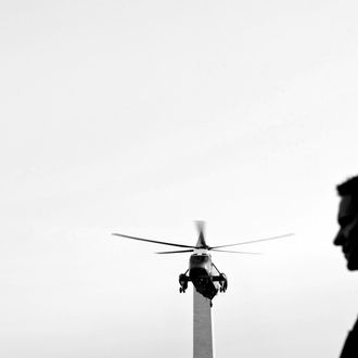 A Secret Service watches as Marine One passes the Washington monument while approaching the South Lawn of the White House with US President Barack Obama on board March 22, 2012 in Washington, DC. President Obama was returning from a two-day trip to Nevada, New Mexico, Oklahoma and Ohio where he stumped the economy and energy. 