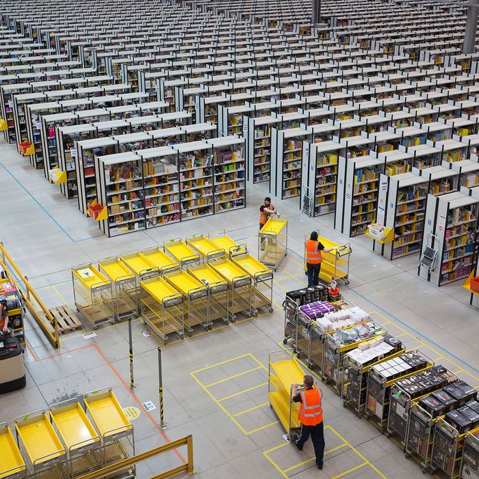 Employees push empty carts as they prepare to process customer orders ahead of shipping at one of Amazon.com Inc.'s fulfillment centers in Rugeley, U.K., on Monday, Dec. 2, 2013. Online retailers in the U.K. are anticipating their busiest day as shoppers flush with end-of-month pay-checks seek Christmas deals on the Web. Photographer: Simon Dawson/Bloomberg via Getty Images
