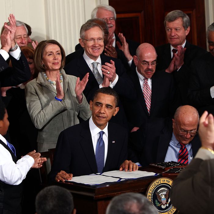U.S. President Barack Obama (C) is applauded after signing the Affordable Health Care for America Act during a ceremony with fellow Democrats in the East Room of the White House March 23, 2010.