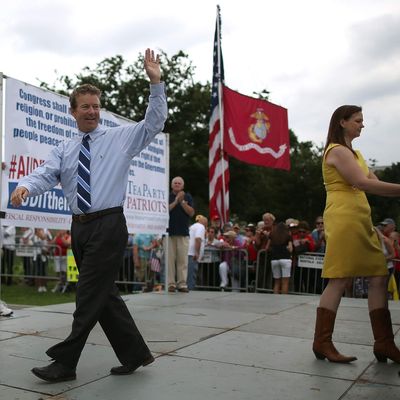 Sen. Rand Paul (R-KY) (L) waves to the crowd while Jenny Beth Martin (R) introduces the next speaker during a Tea Party rally in front of the U.S. Capitol, June 17, 2013 in Washington, DC. The group Tea Party Patriots hosted the rally to protest against the Internal Revenue Service's targeting Tea Party and grassroots organizations for harassment. 
