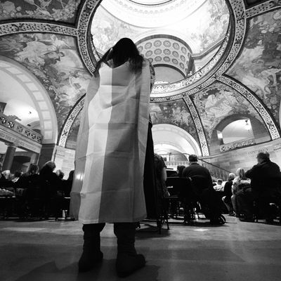 A protester wears a transgender flag around her shoulders inside the Missouri state house.