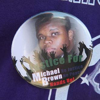 FERGUSON, MO - AUGUST 13: A resident wears a button featuring a picture of Michael Brown during a press conference with Police Chief Thomas Jackson who was fielding questions related to the shooting death of Brown on August 13, 2014 in Ferguson, Missouri. Brown was shot and killed by a Ferguson police officer on Saturday. Ferguson has experienced three days of violent protests since the killing. (Photo by Scott Olson/Getty Images)