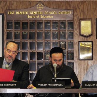 From left, East Ramapo School Board President Daniel Schwartz and board members Yehuda Weissmandl and Eliyahu Solomon attend a board meeting on Tuesday, March 19, 2013, in Spring Valley, N.Y. Allegations of racism and anti-Semitism are afflicting the district, where the board is dominated by ultra-Orthodox Jews and the public school children are mostly black and Hispanic. (AP Photo/Jim Fitzgerald)