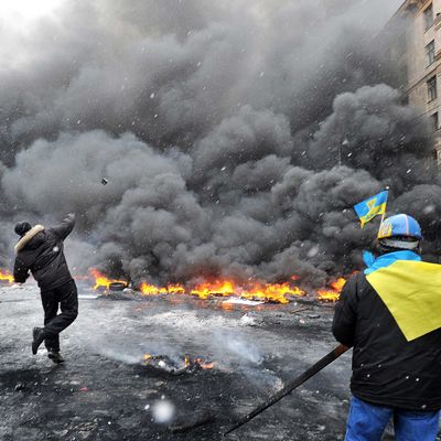Protestors throw stones as they clash with police in the center of Kiev on January 22, 2014. At least two activists were shot dead today as Ukrainian police stormed protesters' barricades in Kiev, the first fatalities in two months of anti-government protests. Pitched battles raged in the centre of the Ukrainian capital as protesters hurled stones at police and the security forces responded with tear gas and rubber bullets. AFP PHOTO / GENYA SAVILOV (Photo credit should read GENYA SAVILOV/AFP/Getty Images)
