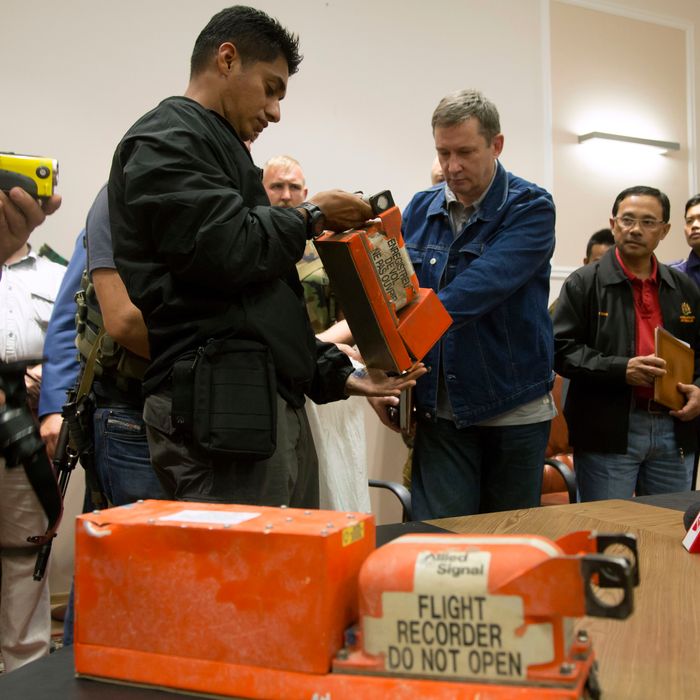 A Malaysian investigator, left, takes a black box from Malaysia Airlines Flight 17 as it is handed over by a Donetsk People's Republic official in the city of Donetsk, eastern Ukraine Tuesday, July 22, 2014. Bowing to international pressure Monday, pro-Moscow separatists released a train packed with bodies and handed over the black boxes from the downed Malaysia Airlines plane, four days after it plunged into rebel-held eastern Ukraine. (AP Photo/Dmitry Lovetsky)