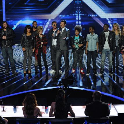 Host Steve Jones (C) and the top 10 contestants stand before the judges on THE X FACTOR airing Thursday, Nov. 17.