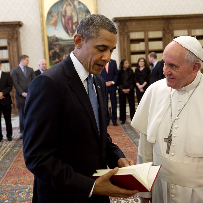 Pope Francis (R) presents a book to US President Barack Obama as they exchange gifts during a private audience on March 27, 2014 at the Vatican. The meeting at the Vatican comes as a welcome rest-stop for Obama during a six-day European tour dominated by the crisis over Crimea, and the US leader will doubtless be hoping some of the pope's overwhelming popularity will rub off on him. AFP PHOTO / SAUL LOEB