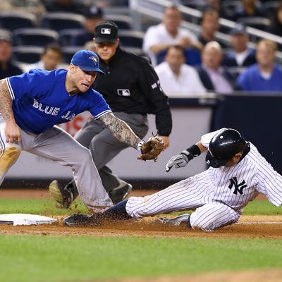 Ichiro Suzuki #31 of the New York Yankees steals third base as Brett Lawrie #13 of the Toronto Blue Jays is late with the tag during their game on September 19, 2012 at Yankee Stadium in the Bronx borough of New York City 
