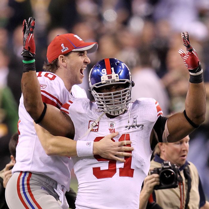 Eli Manning #10 of the New York Giants celebrates with Justin Tuck #91 after defeating the New England Patriots in Super Bowl XLVI at Lucas Oil Stadium on February 5, 2012 in Indianapolis, Indiana. The New York Giants defeated the New England Patriots 21-17.
