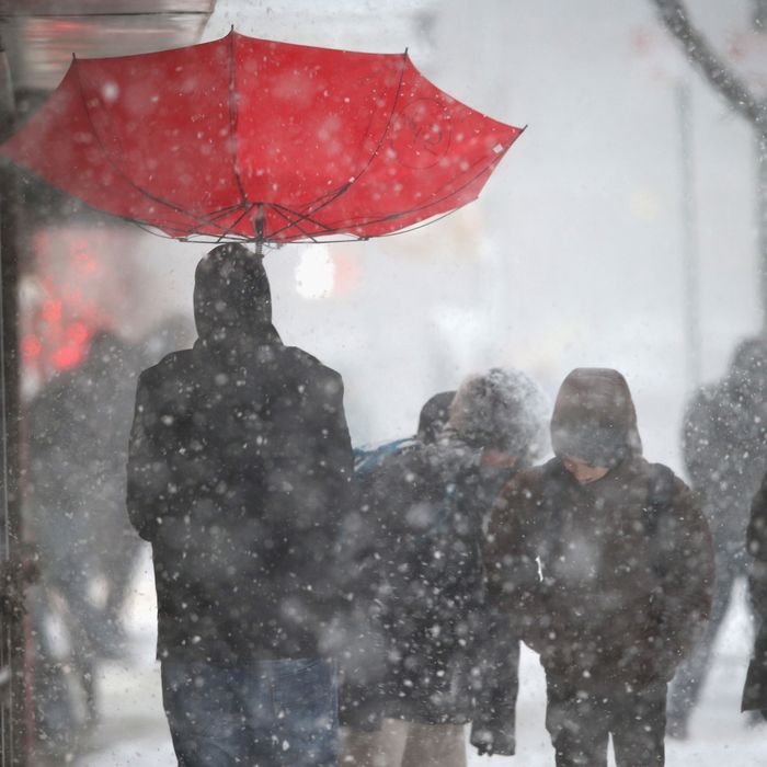 A person walks with an upturned umbrella during a snowstorm on February 13, 2014 in New York City. Heavy snow and high winds made for a hard morning commute in the city.