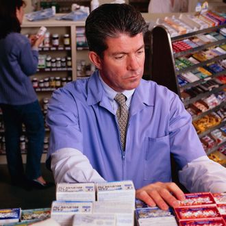 Pharmacist at Drug Shelves.