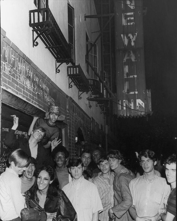An unidentifed group of young poeple celebrate outside the boarded-up Stonewall Inn (53 Christopher Street) after riots over the weekend of June 27, 1969. The bar and surrounding area were the site of a series of demonstrations and riots that led to the formation of the modern gay rights movement in the United States. (Photo by Fred W. McDarrah/Getty Images)