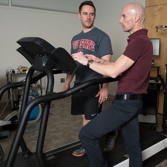 Steven Devor, front, discusses the new automated treadmill with doctoral student Rich LaFountain.