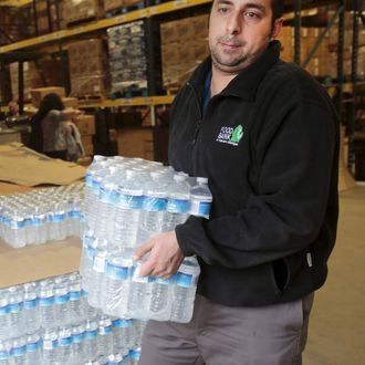 Food Bank of Eastern Michigan worker Filipovich helps to load bottled water in the agency's warehouse that will be distributed to the public, after elevated lead levels were found in the city's water in Flint